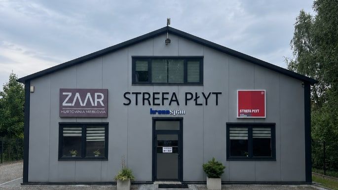 Budynek zakładu ZAAR Strefa Płyt z szyldem hurtowni od strony wjazdu